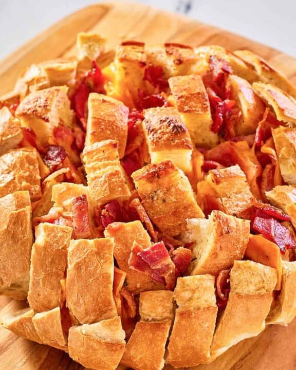cheesy pull apart bread on a wood board.