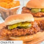 Homemade Chic Fil A spicy chicken sandwich and waffle fries behind it.