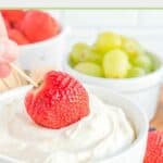 Dipping a strawberry into cream cheese fruit dip.