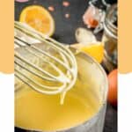 homemade hollandaise sauce on a whisk over a pan with the sauce.