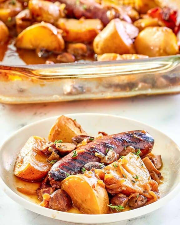 Irish coddle serving on a white plate in front of it in a baking dish.
