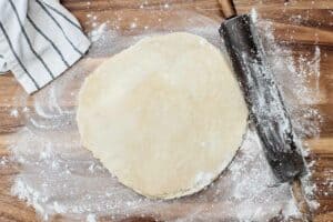 rolled out pie crust dough and a rolling pin.