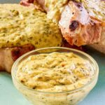 Mustard cream sauce in a small bowl and over pork chops on a plate.