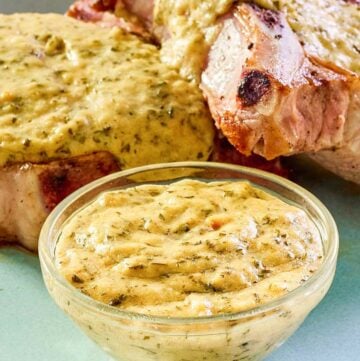 Mustard cream sauce in a small bowl and over pork chops on a plate.
