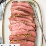 Slices of New York strip roast and a meat fork on a platter.
