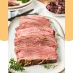 New York strip roast slices on a white platter.