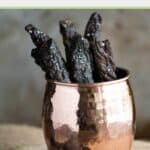 Strips of homemade teriyaki beef jerky in a brass cup.