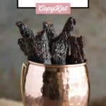 Homemade teriyaki beef jerky strips in a cup.