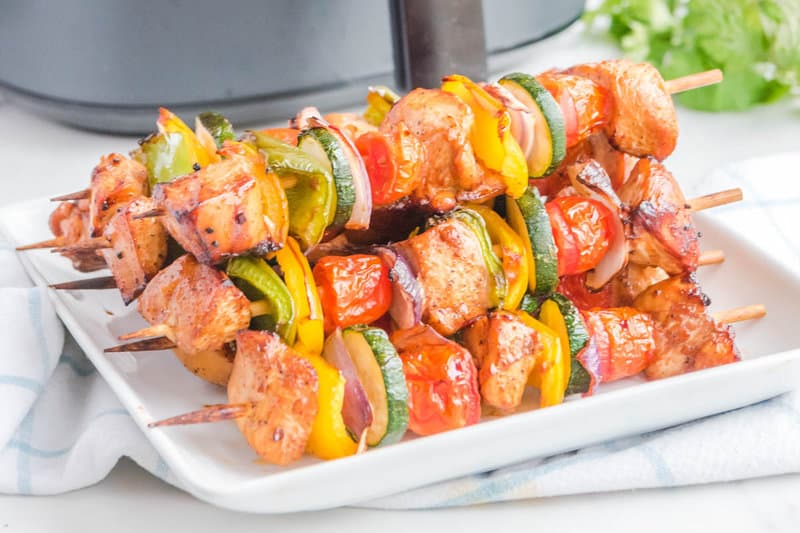 Air fried chicken kabobs on a white plate.