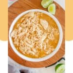 Overhead view of homemade Cafe Rio shredded chicken in a bowl on top of a wood board.