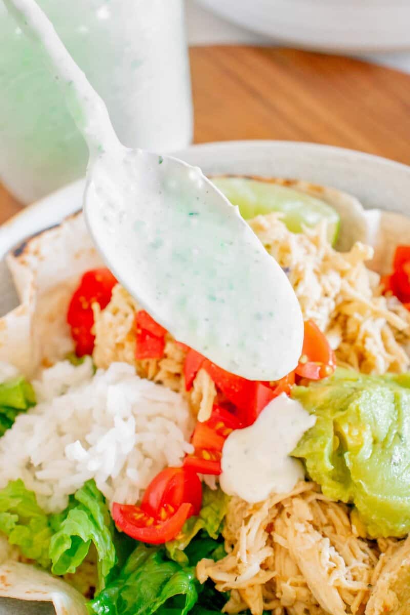 A spoonful of tomatillo dressing over a salad.