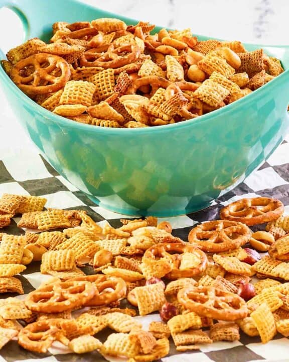 Homemade original Chex mix in a bowl and on parchment paper.