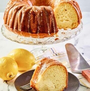 Cream cheese coffee cake on a cake stand and a slice on a plate.