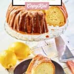 Lemon cream cheese coffee cake on a cake stand and a slice on a black plate.