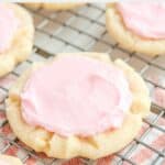 A homemade Crumbl sugar cookie on a wire rack.