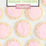 Overhead view of homemade Crumbl sugar cookies scattered on a marble surface.