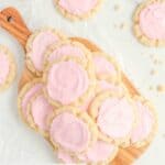 Overhead view of homemade Crumbl sugar cookies on a wood board.