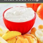 Bowl of cool whip fruit dip and slices of fresh fruit.