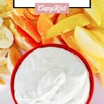 Overhead view of cool whip fruit dip in a red bowl and fresh fruit.