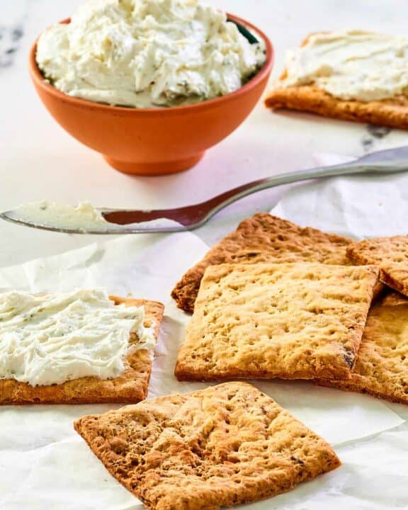 Homemade crackers and a bowl of a cheese spread.