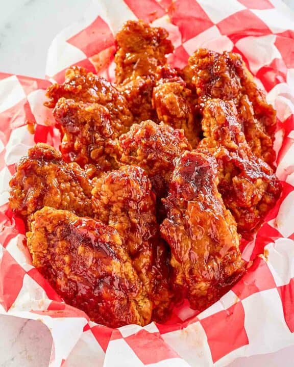 Copycat KFC honey bbq chicken wings in a parchment lined basket.