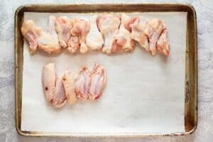 Raw chicken wing drumettes and flats on a tray.