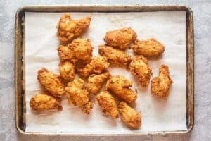 Deep fried chicken wings on a tray.