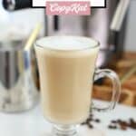 Homemade Starbucks flat white coffee in a glass mug in front of an espresso machine.
