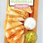 Overhead view of copycat Taco Bell chicken quesadilla, guacamole, and sour cream.