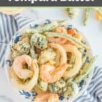 Overhead view of tempura batter fried veggies and shrimp on a plate.