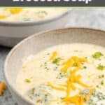 Bowl of three cheese broccoli soup garnished with shredded cheese.