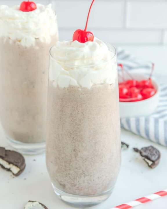 Copycat Chick Fil A cookies and cream milkshake, straws, Oreos, and cherries.