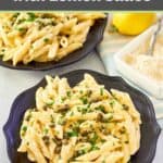 Greek pasta with lemon sauce on black plates and a small dish of parmesan cheese.