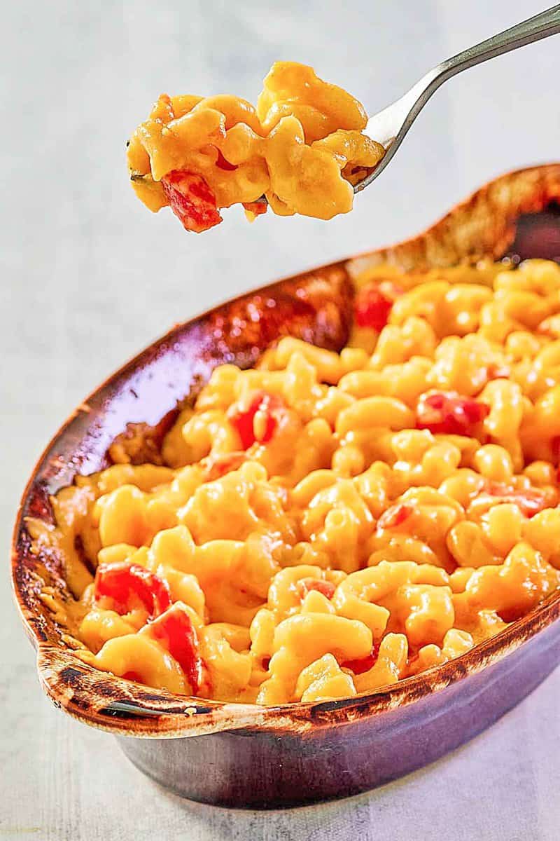 Copycat Horn and Hardart mac and cheese on a fork over a dish of it.