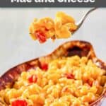 Homemade Horn and Hardart macaroni and cheese with tomatoes on a fork over a dish of it.