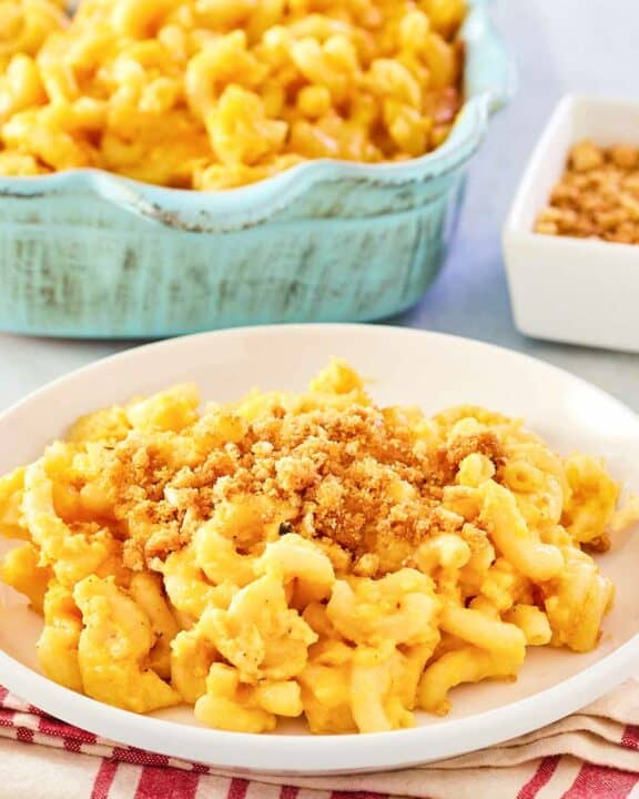 Homemade mac and cheese with bread crumbs in a baking dish and on a plate.