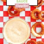 Overhead view of copycat Outback bloomin onion sauce in a small bowl and onion rings.