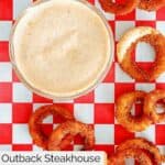 Overhead view of homemade Outback bloomin onion sauce in a bowl and onion rings.