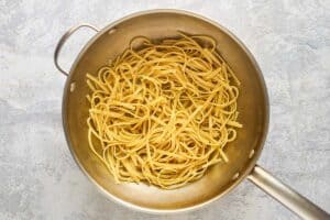 Partially cooked fettuccine pasta in a pot.