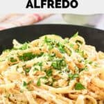 Closeup of homemade Pasta House Company fettuccine alfredo in a black bowl.