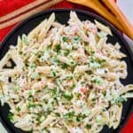 Overhead view of seafood pasta salad on a black plate.