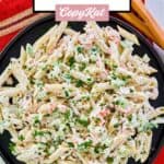 Overhead view of seafood pasta salad in a large black serving bowl.