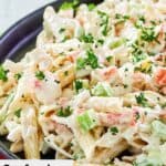 Closeup of seafood pasta salad in a black bowl.