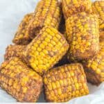 Homemade Wingstop Cajun fried corn on the cob on white parchment paper.