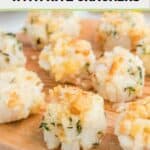 Baked scallops with Ritz crackers on a wood board.