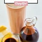 A glass of chocolate milk and homemade chocolate syrup next to it.