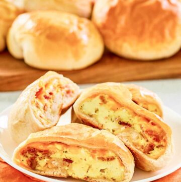 Copycat Dunkin stuffed biscuit bites with bacon on a wooden board and a plate.