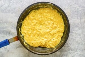 Cooked scrambled eggs in a skillet.