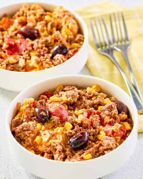 Two servings of hamburger corn casserole in white bowls.