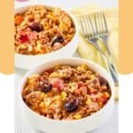 Two bowls of hamburger corn casserole and two forks.
